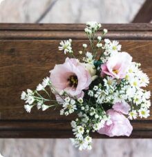 En kista dekorerad med en bukett av rosa och vita blommor.